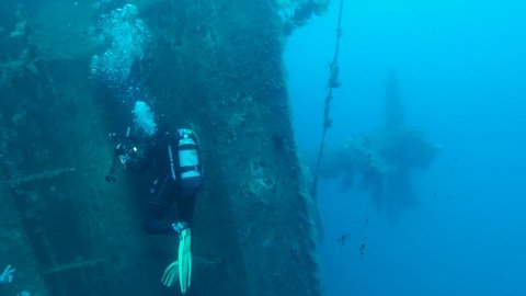 MEDITERRANEAN SEA, CYPRUS - AUGUST, 2021: Scuba diver photographer swims on the shipwreck Swedish ferry MS Zenobia. Wreck diving. Mediterranean sea, Cyprus