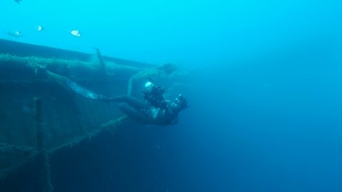 MEDITERRANEAN SEA, CYPRUS - AUGUST, 2021: Free diver photographer swims on the shipwreck Swedish ferry MS Zenobia. Wreck diving. Mediterranean sea, Cyprus