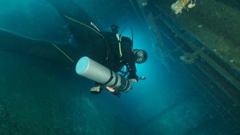 MEDITERRANEAN SEA, CYPRUS - AUGUST, 2021: Scuba diver swims inside of the shipwreck Swedish ferry MS Zenobia. Wreck diving. Mediterranean sea, Cypru