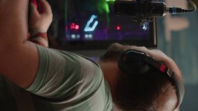 Vertical video: Nevous streamer losing videogame, game over for man cyber playing online space shooter games with headset. Player performing on powerful computer talking with players on chat in gaming