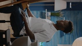 Vertical video: Black man in art studio preparing for creativity process designing masterpiece. African american person using pencil and tools for professional modern drawing of authentic white vase