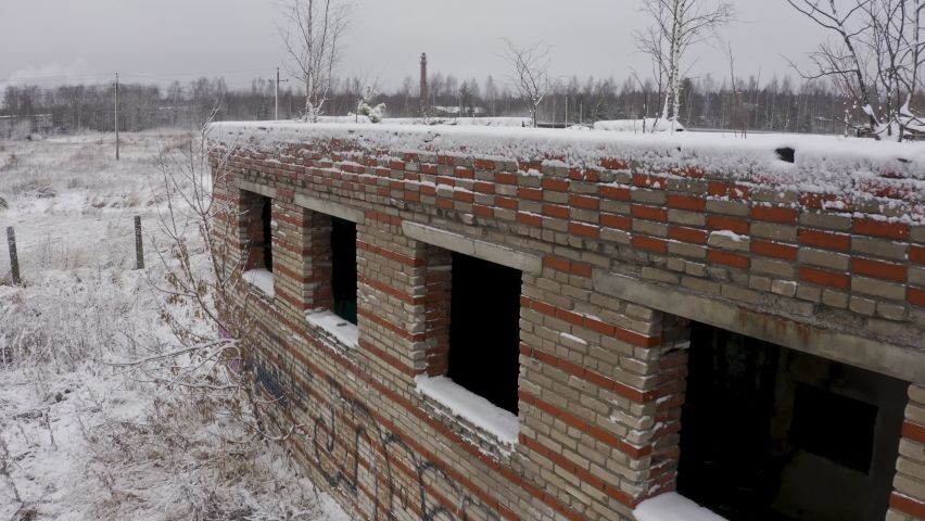An abandoned building from the times of the USSR in winter on an overgrown place. strange landscape