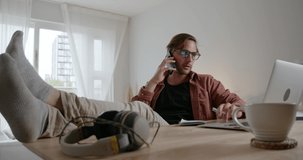 Caucasian male working from home chatting on cellular device