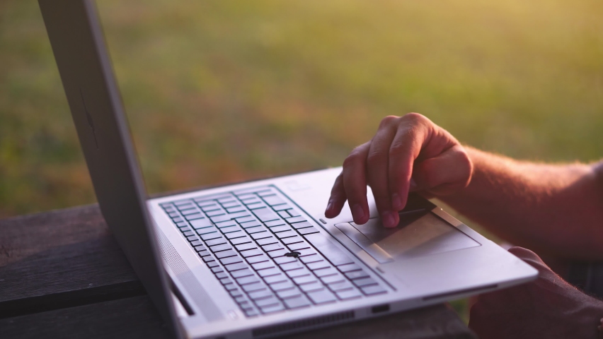 Young successful freelancer using his laptop computer outdoors. Digital nomad lifestyle during coronavirus quarantine. Concept of freelancing, global connection, success and technology. | Shutterstock HD Video #1078122731
