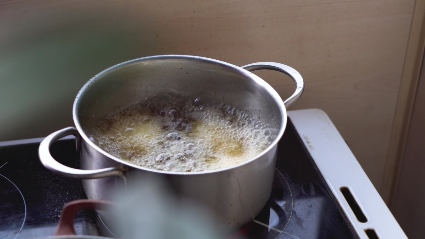 High angle view of a steel pot full of boiling oil. Deep frying food. Concept on unhealthy lifestyle, cholesterol, calories, fast and junk food. | Shutterstock HD Video #1078122734