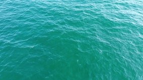 Top View Slow motion looping c ripples and wave, Refraction of sunlight top view texture sea side, Foaming and Splashing in the Ocean, Sunny Day, Slow Motion Video. Veiw from drone