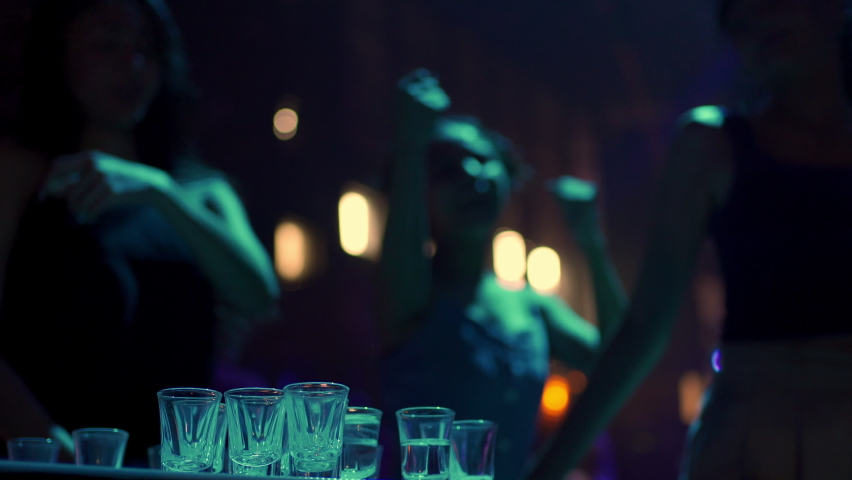 4K Group of Beautiful Asian woman dancing to the music with drinking alcoholic drink on table at night club. Pretty woman friends enjoy and having fun nightlife crazy dance together at nightclub party