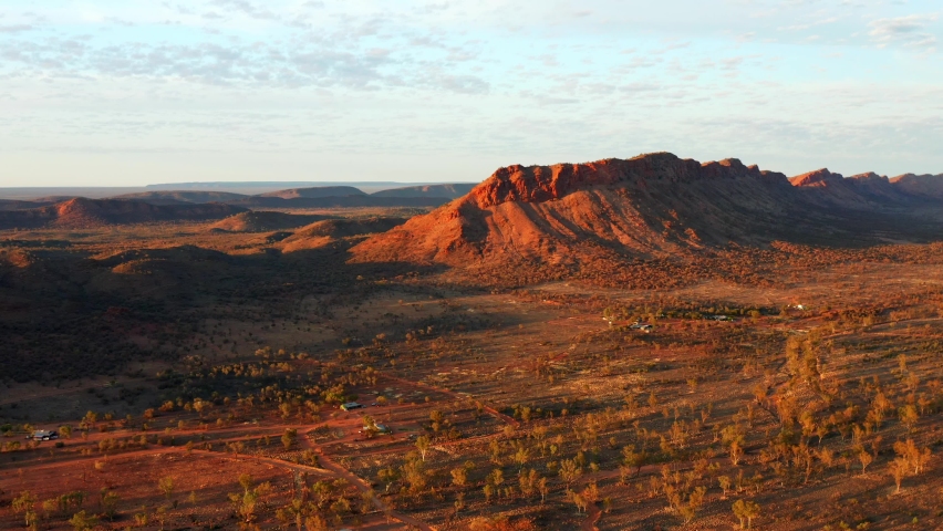 Distant View Of The Rocky Mountain Amidst The Red Sand Dunes In Alice Springs Town, Australia. aerial Royalty-Free Stock Footage #1078133354