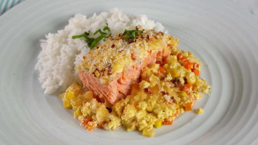 baked salmon with diced corn and carrots in garlic cream sauce and cheese