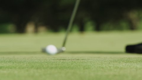 Close up of a guy missing a put at the golf course.