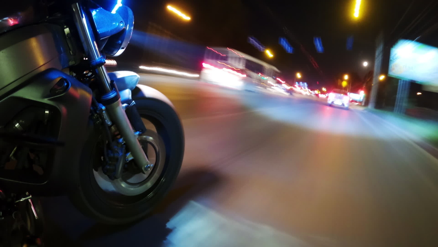 Fast Driving Bike on Streets of Night City Time Lapse. Speed Motion in Cityscape Illumination Neon. Wheel Fast Driving. Pov View Motorcyclist Drives on Motorcycle on Road in the City Hyper Lapse 4k Royalty-Free Stock Footage #1078138394