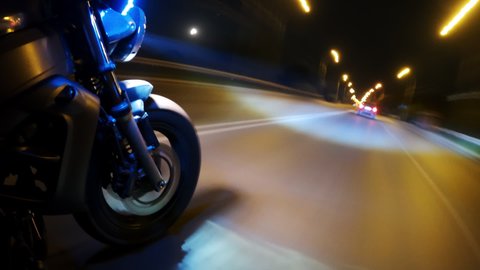 Fast Driving Bike on Streets of Night City Time Lapse. Speed Motion in Cityscape Illumination Neon. Wheel Fast Driving. Pov View Motorcyclist Drives on Motorcycle on Road in the City Hyper Lapse 4k