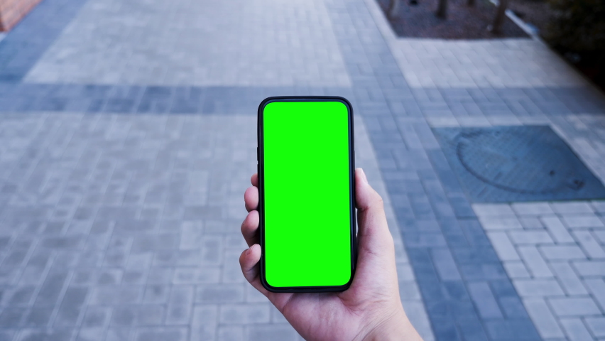 Person Hold in Hand Smartphone with Green Screen Chroma Key and Talking of Video Call. Young Adult Caucasian Man Use Phone for Social Networks or e-Shopping. Walk Concept with Look Display Smart Tech | Shutterstock HD Video #1078138400