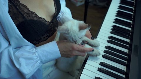 The cat and the mistress are playing the piano. A fun time in quarantine. Slow motion.