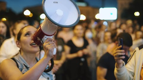 Khabarovsk, Russia - 25.07.20: Protest people crowd and feminists on riot, demonstration rally in defense of governor Sergey Furgal. Feminist Protester chants with bullhorn megaphone on picket strike.