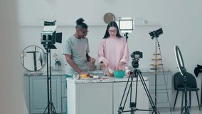 African-american man and a lady are getting filmed in a cooking vlog