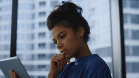 Pensive businesswoman working tablet computer in office. Thoughtful business woman reading information on digital gadget pad. Black woman thinking. Ceo top manager typing message in online application - Powered by Shutterstock - Get 15% off with code: PIKWIZARD15