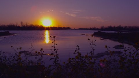 Dolly shot of sunset overlooking a lake in Nebraska.