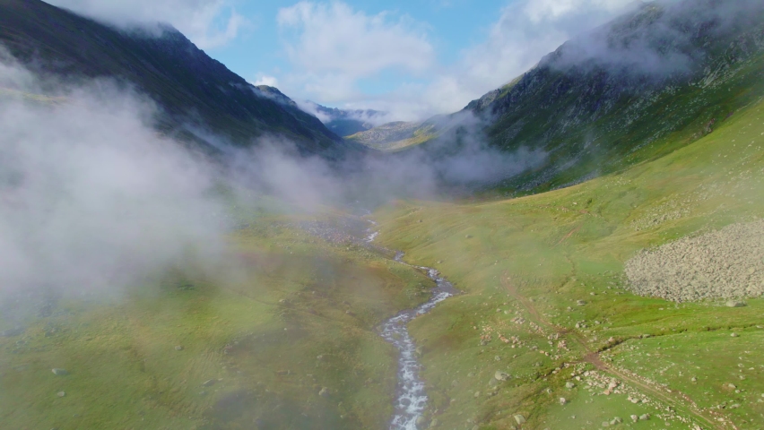 foggy mountain landscape, river in green meadow, freshwater stream on a foggy morning in sunny mountain valley, aerial view of wild natural environment, Turkey Kackar natural reserve . 