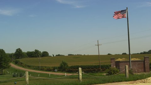 American Flag blowing in front of fields of crops in Nebraska.