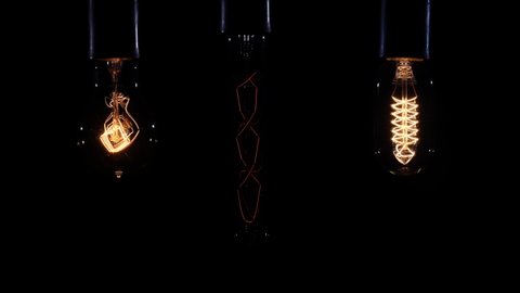 Set of filament lamp with a tungsten spiral pendant lantern lights up and goes out on a black backdrop.