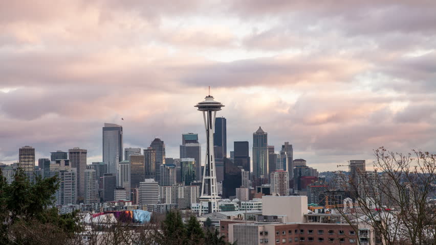 Seattle, Washington establishing cityscape shot.  Time lapse clouds looking toward downtown and the Space Needle at Sunset.