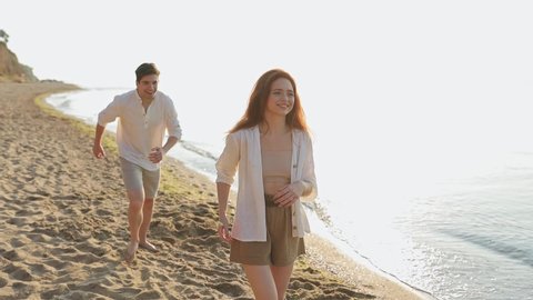 Laughing romantic young couple two friends family man woman 20s in white clothes play catching up fooling around together at sunrise over sea beach ocean outdoor seaside in summer day sunset evening