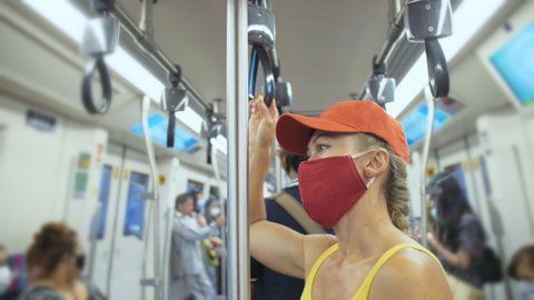 Woman travel caucasian ride at overground train airtrain with wearing protective medical mask. Girl tourist at airtrain with respirator. People mask.