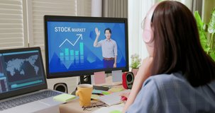 rear view of asian woman learns stock market invest mention online through computer with headset at home