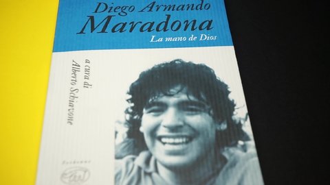 Rome, Italy - August 25, 2021, detail of the book on an extensive and accurate biography, with complete football, by Diego Armando Maradona nicknamed The Hand of God.