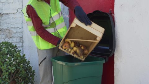 Uneaten or unsold food. Food Waste at Retail. Grocery store worker or farmer throw spoiled unsold uneaten rotten grapes into dumpster