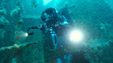 MEDITERRANEAN SEA, CYPRUS - AUGUST, 2021: Scuba diver swims out of the interior of the shipwreck Swedish ferry MS Zenobia. Wreck diving. Mediterranean sea, Cypru