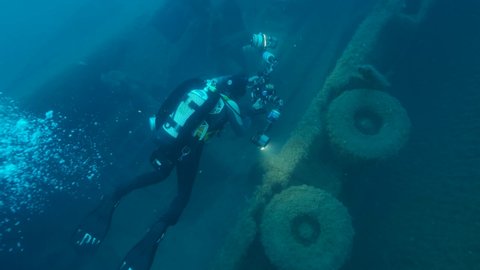 MEDITERRANEAN SEA, CYPRUS - AUGUST, 2021: Scuba diver photographer shots truck on the shipwreck Swedish ferry MS Zenobia. Wreck diving. Mediterranean sea, Cyprus