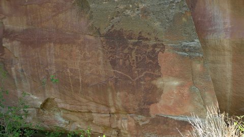 Petroglyphs At Capitol Reef National Park In Utah. Rock Art Figures Carved On Sheer Cliff. medium shot