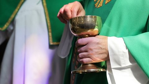 A Catholic priest distributes a prosphora from a bowl to believing parishioners. Liturgical liturgical bread used in Orthodoxy for the sacrament of the Eucharist.priest gives altar breads.
