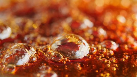 Boiling sugar with bubbles turns into caramel, caramelization. Macro shot. Slow motion.