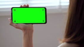 a smartphone in the hands of a green screen