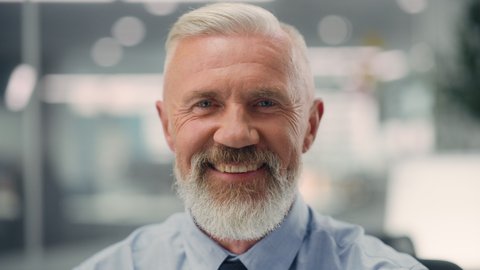 Portrait of a Confident Happy Senior Male Wearing Blue Shirt, Looking at Camera, Genuinely and Charmingly Smiling. Successful Experienced Older Man Working in Diverse Company Office.