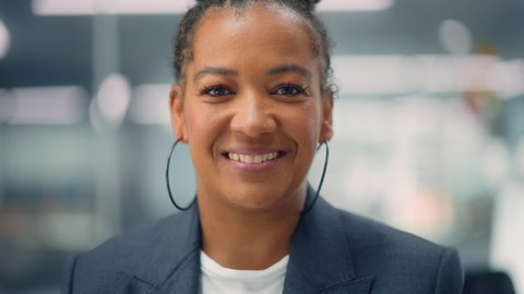 Portrait of a Confident Happy Adult Middle Aged African American Female Wearing Dark Jacket, Looking at Camera, Posing and Charmingly Smiling. Successful Black Woman Working in Diverse Company Office.
