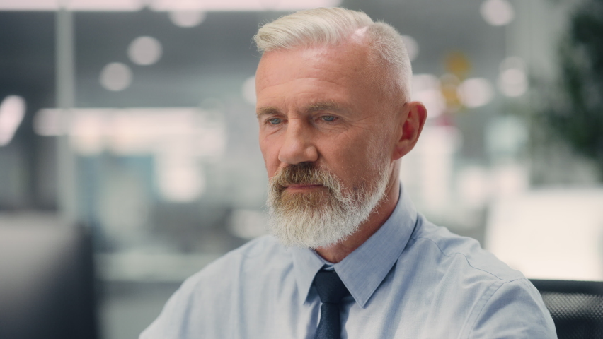 Portrait of a Confident Happy Senior Male Wearing Blue Shirt, Looking at Camera, Genuinely and Charmingly Smiling. Successful Experienced Older Man Working in Diverse Company Office. Royalty-Free Stock Footage #1078185014
