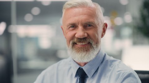 Portrait of a Confident Happy Senior Male Wearing Blue Shirt, Looking at Camera, Genuinely and Charmingly Smiling. Successful Experienced Older Man Working in Diverse Company Office.