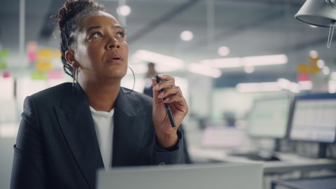 Busy African American Female Manager Using Computer in Modern Office. Overworked Tired Employee Dealing with Hard Work Tasks. Stressed Beautiful Woman Exhausted to Come Up with New Business Ideas.