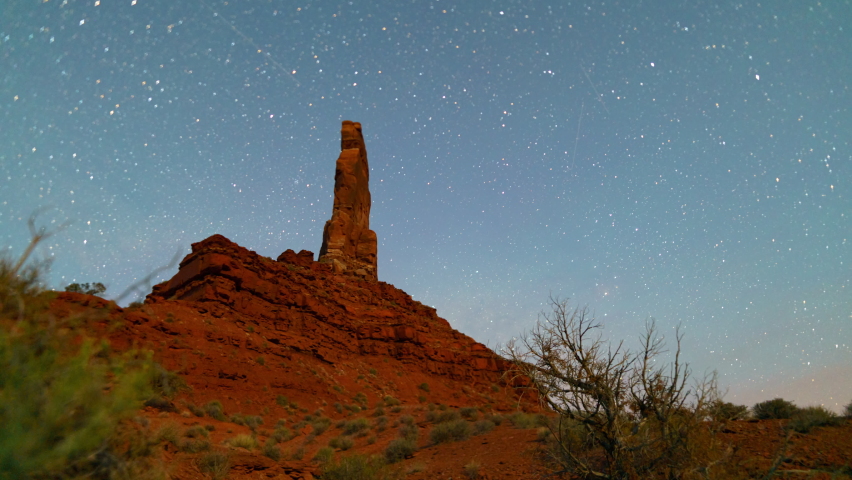 Time lapse tracking shot of Milky Way galaxy over rock formations in Valley of the Gods in Utah