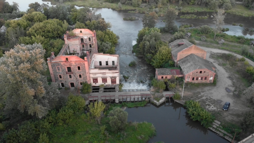Old abandoned mill at sunrise. Waterfall with river at old antique stone mill in sunlights. Epic countryside landscape