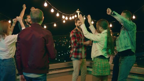 Multiracial people have a party time on the rooftop of terrace they dancing and feeling excited enjoy the time together. Shot on ARRI Alexa Mini.