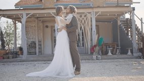 Hippie-style wedding. Action. Beautiful couple of newlyweds in vintage outfits hold wedding ceremony. Newlyweds are getting married on background of wooden house. Conceptual wedding