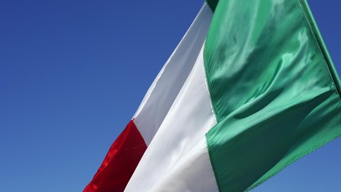 Italian flag flying on the blue sky. Flag of Italy. Slow Motion.