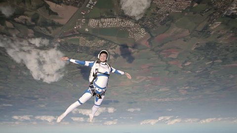 Skydiver freestyle beautiful girl in white suit. Extreme sports