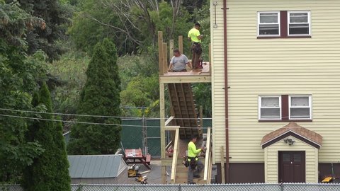 4K Carpenters build two level porch and staircase on back of house, Revere Massachusetts USA, August 24 2021