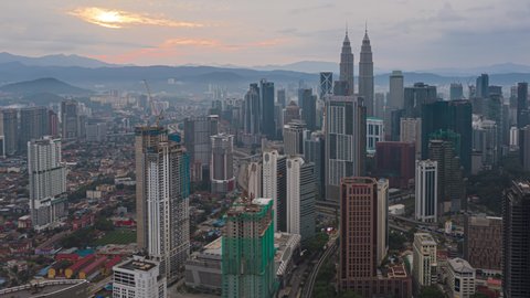 KUALA LUMPUR, MALAYSIA - JUNE 27 : Time lapse of Kuala Lumpur city view overlooking the city skyline during cloudy sunrise on June 27, 2020 in Malaysia. Zoom in motion timelapse.